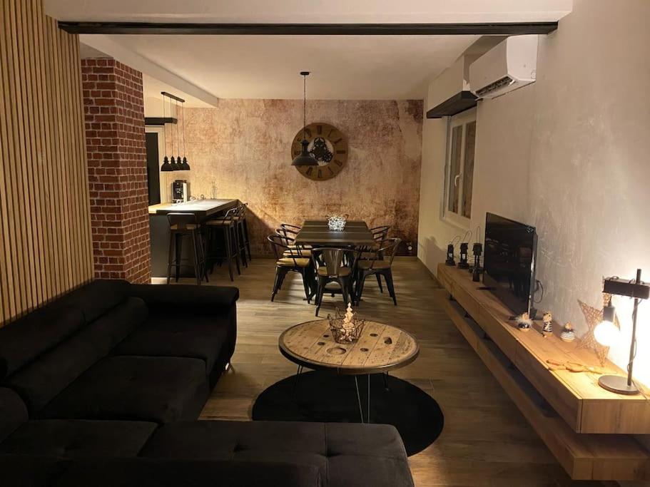 ein Wohnzimmer mit Sofa und Tisch in der Unterkunft Als AS DE COEUR La maison aux mille et un coeurs in Neuve-Église