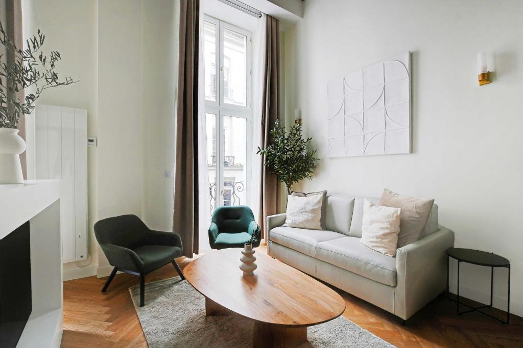 un salon avec un canapé et une table dans l'établissement Charming Apartment - 1BR-5P - Sentier, à Paris