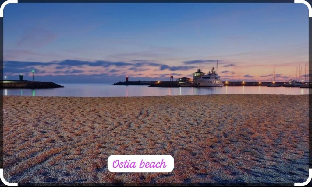 una playa de arena con un barco en el agua en LA REGINA, en Lido di Ostia