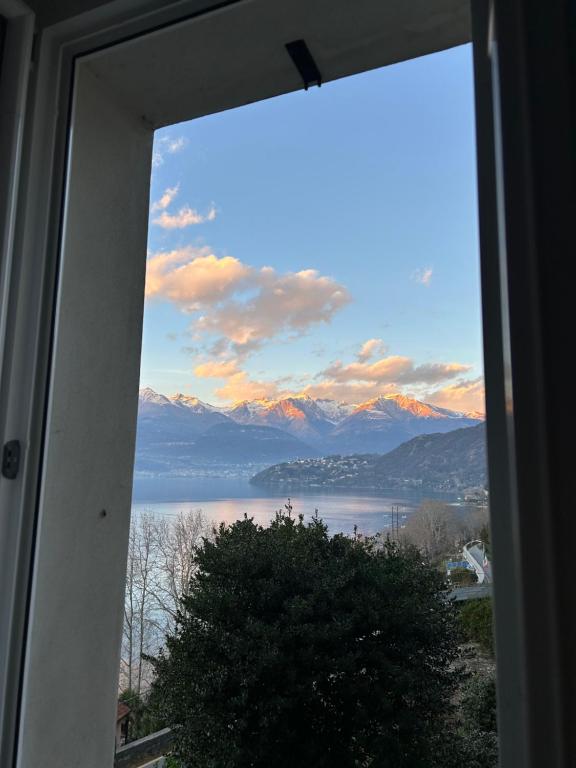 ventana con vistas al agua y a las montañas en Appartamento Ai Crotti, en Dervio