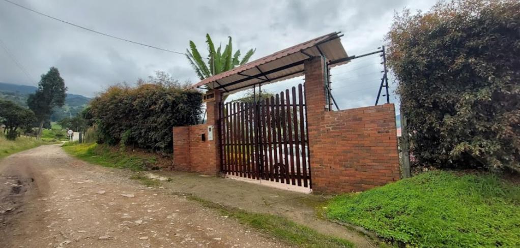 een bakstenen gebouw met een poort op een onverharde weg bij Cabaña Mi Terruño in Cogua