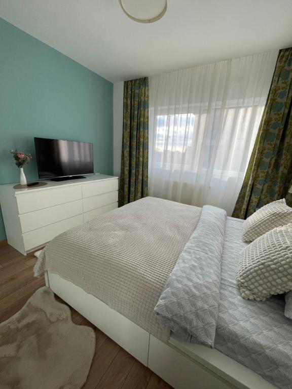 um quarto com uma cama e uma televisão de ecrã plano em EliteVista by Cristian em Timisoara