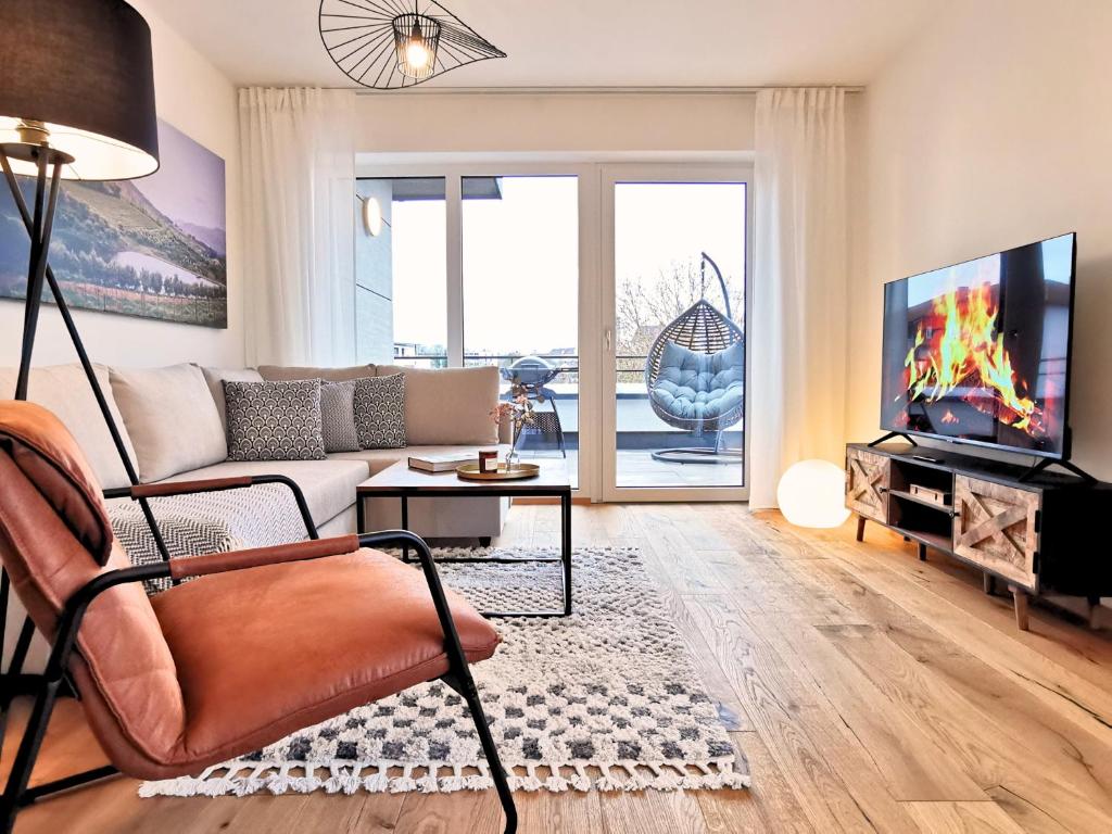 a living room with a couch and a tv at Fynbos Penthouse Deluxe, Balkon, Parkplatz in Straubing