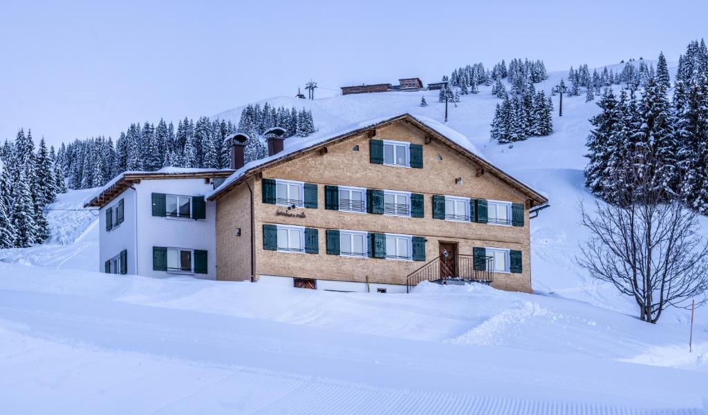 una casa grande en la nieve con nieve en Ferienhaus Erath, en Damüls