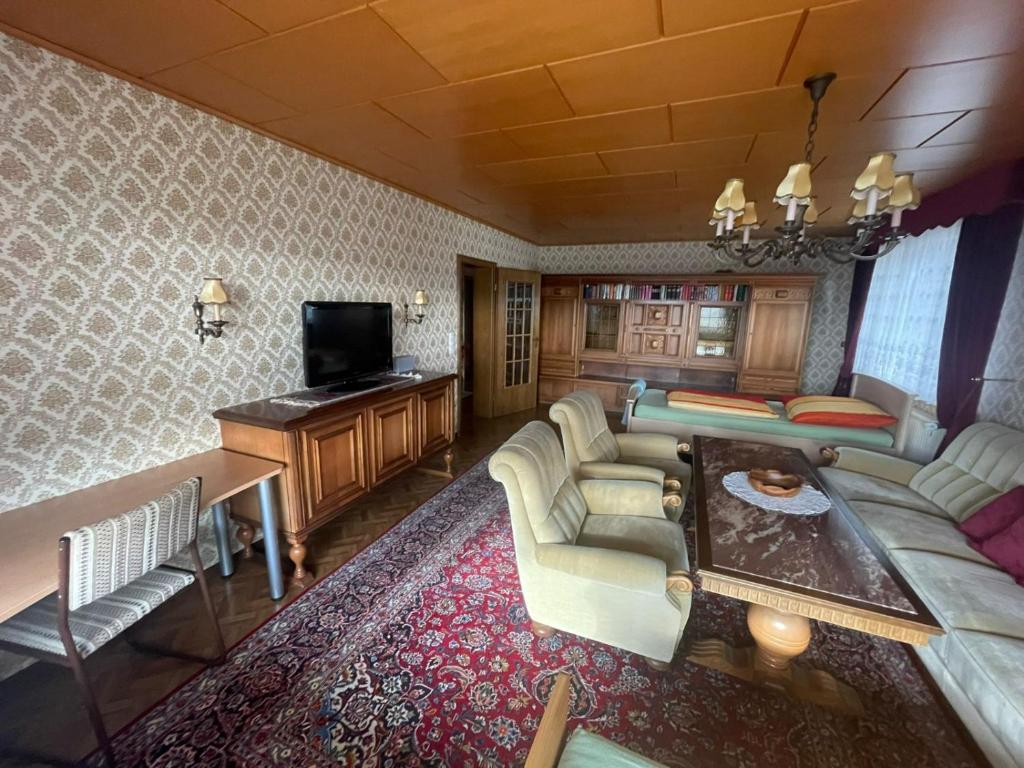 uma sala de estar com um sofá e uma televisão em Wohngemeinschaft mit 3 privaten Zimmern, jedes Zimmer hat 2 Betten 