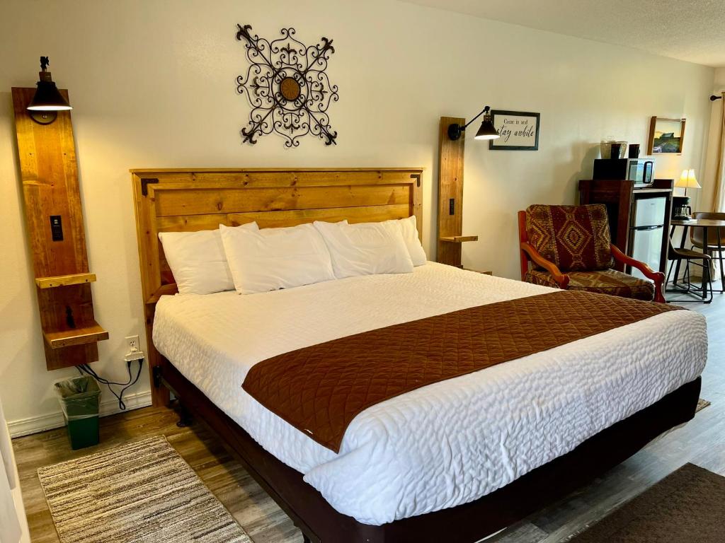 芒廷維尤的住宿－Mountain View Guest Motel，一间卧室配有一张大床和一把椅子
