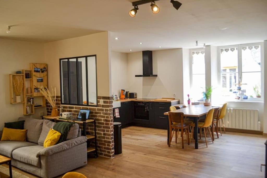 un salon avec un canapé et une table et une cuisine dans l'établissement Résidence Caladoise - Rue Centrale, à Villefranche-sur-Saône