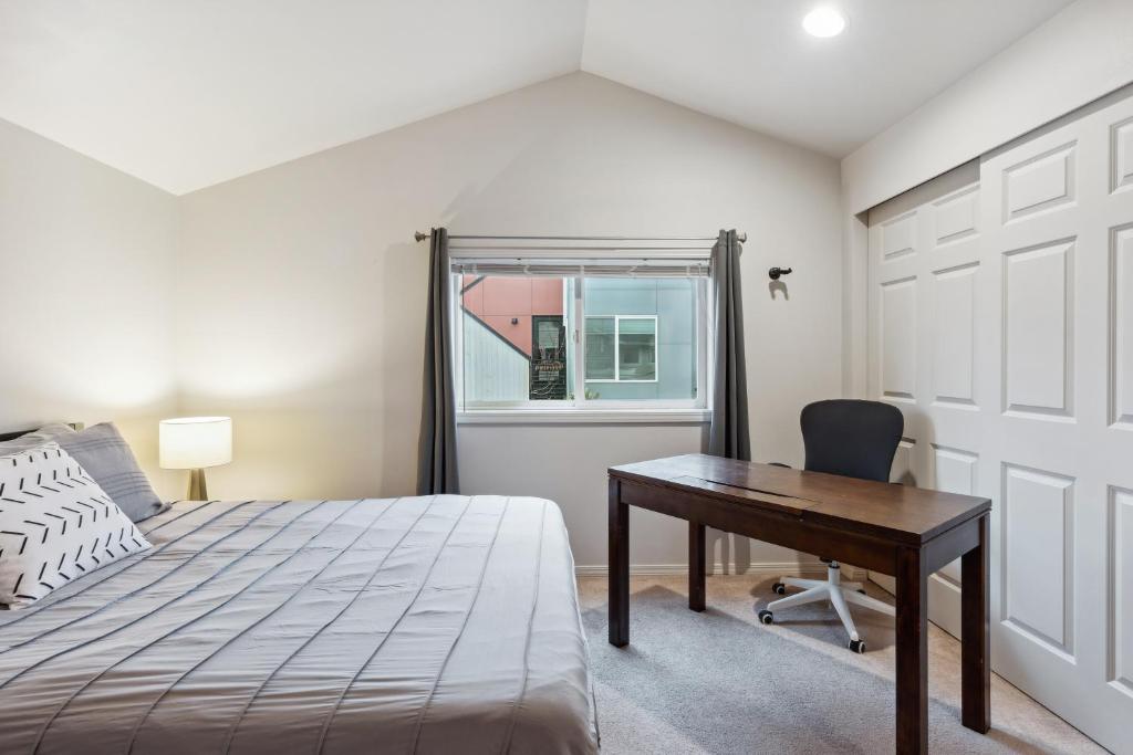 um quarto com uma cama, uma secretária e uma janela em 2BR Seattle Oasis - A Short Stroll to Light Rail em Seattle