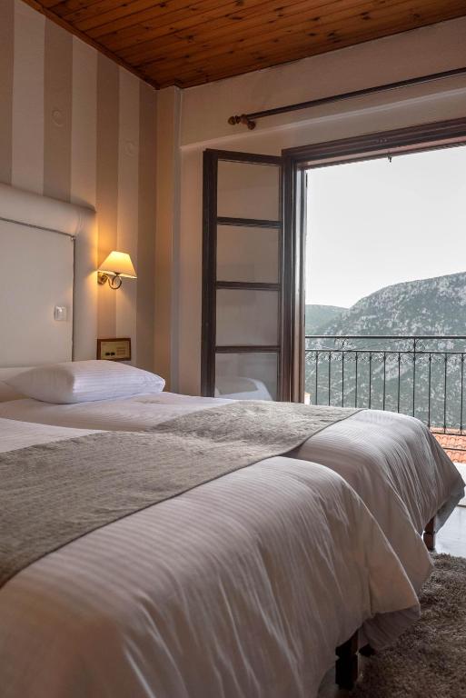Postel nebo postele na pokoji v ubytování Kouros Hotel
