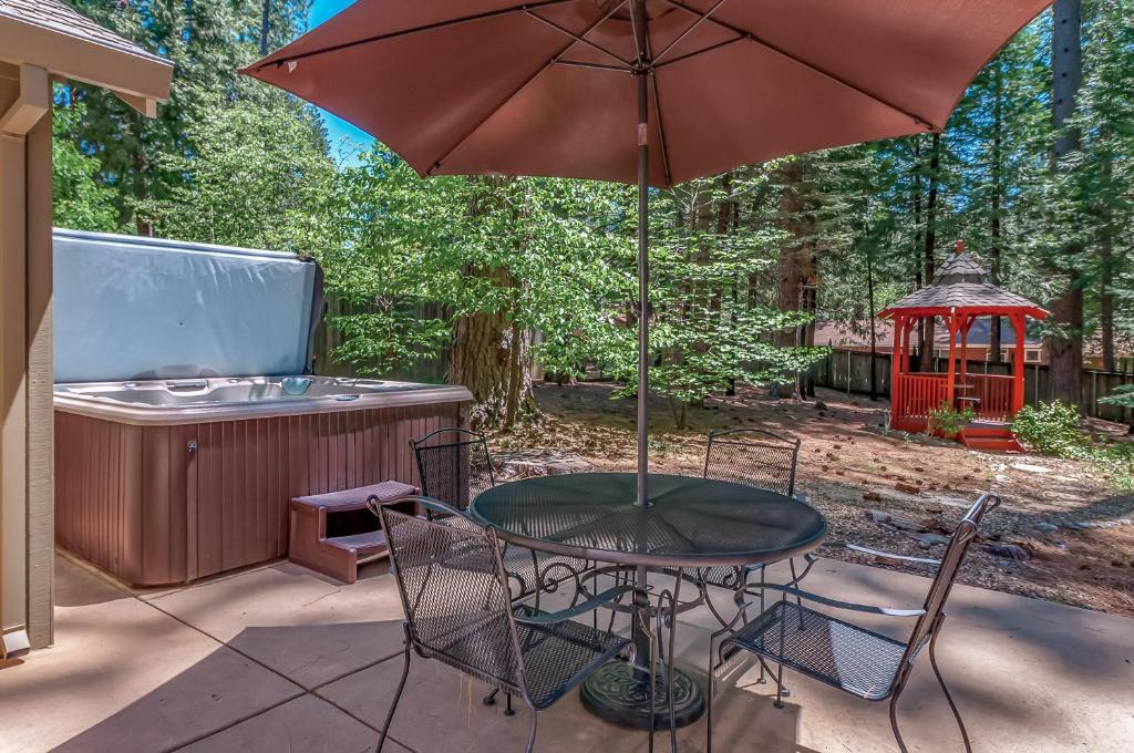 a table and chairs with an umbrella and a gazebo at Arnold Schwartzencabin in Arnold