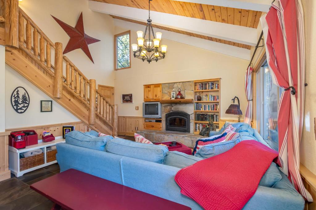 a living room with a blue couch with a red blanket at Candys Cottage in Camp Connell