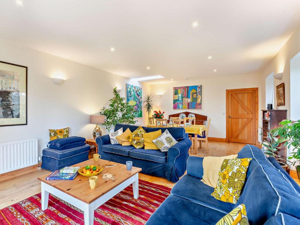 a living room with blue couches and a table at 2 Bed in Coldingham 93242 in Duns