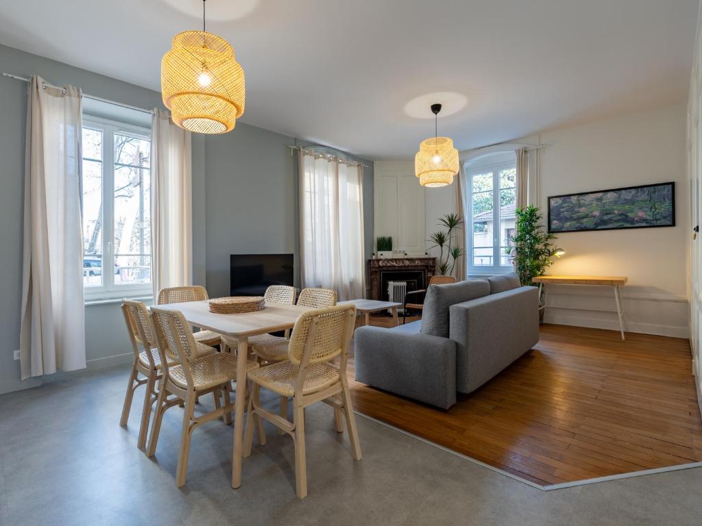 a living room with a table and chairs and a couch at Le cocon urbain T3, 6 personnes, avec parking proche TRAM ET METRO in Villeurbanne