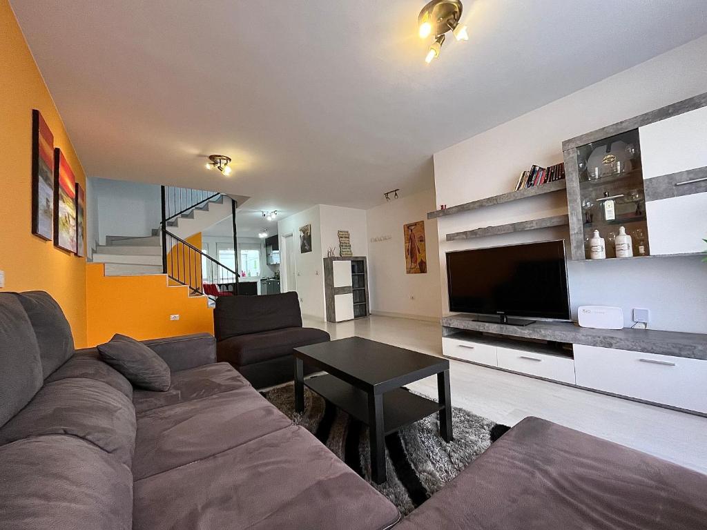 a living room with a couch and a tv at Casa La Laguna in Las Lagunas