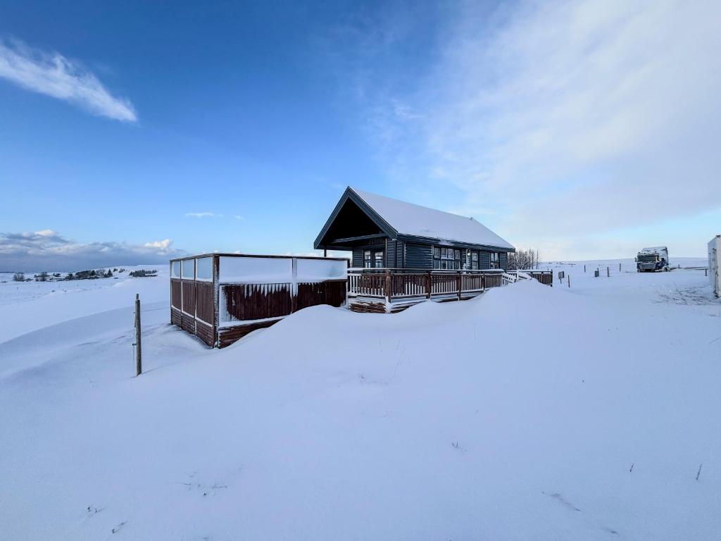 una casa en la nieve con un campo cubierto de nieve en Áshamrar en Hella