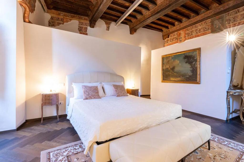 um quarto com uma grande cama branca e uma mesa em centro storico - LUXURY EXPERIENCE NARNI VINTAGE ÉLITE SUITE em Narni