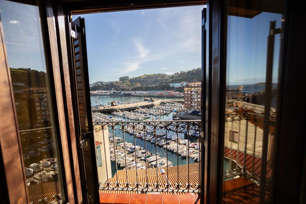 a view of a harbor from a window at Apartamentos Bermeo, Museoa in Bermeo