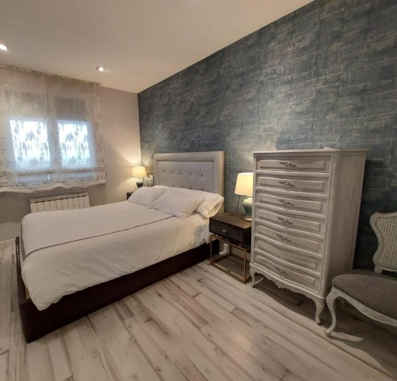 ポンフェラーダにあるEl Silencio de Galadhrimのベッドルーム1室(ベッド1台、ドレッサー、椅子付)