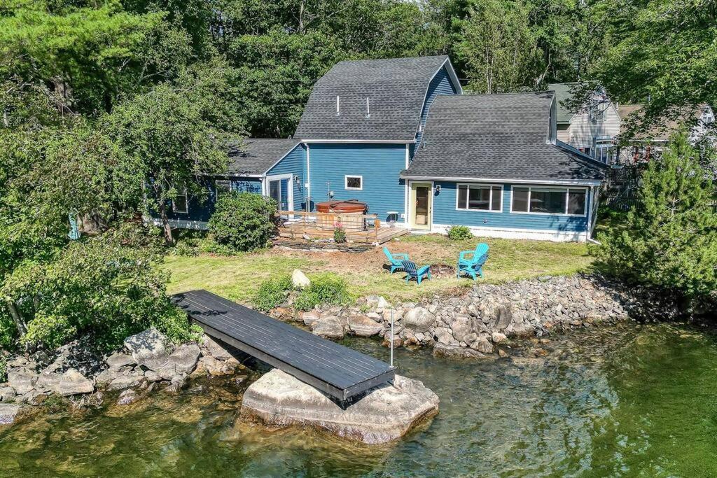 una casa azul con un muelle en el agua en Lakefront Trifecta with Hot Tub & Free Massages en Augusta