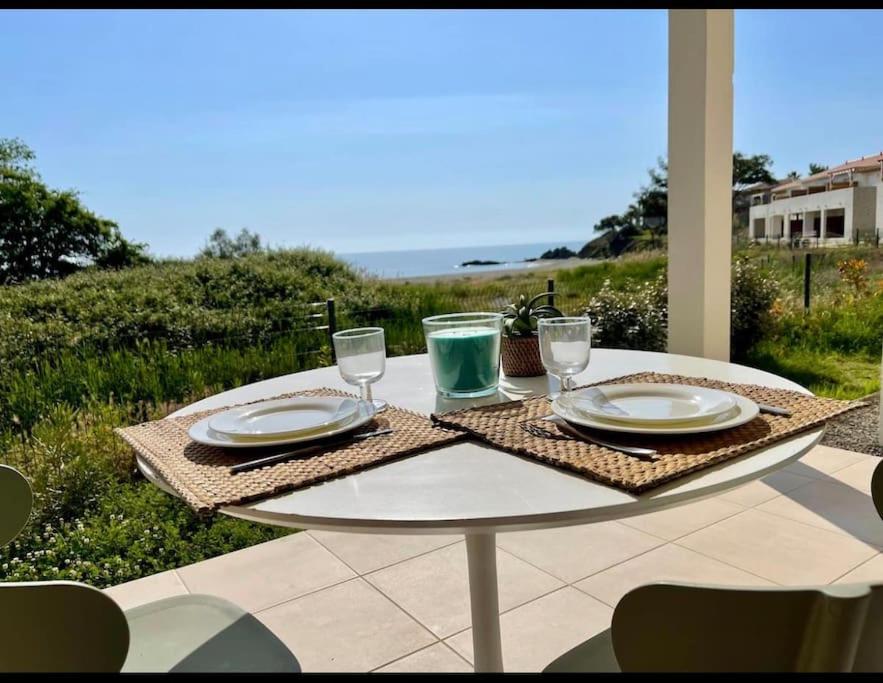 - une table avec des assiettes et des verres sur la terrasse dans l'établissement Studio design front de mer classé 3 étoiles, à Linguizzetta