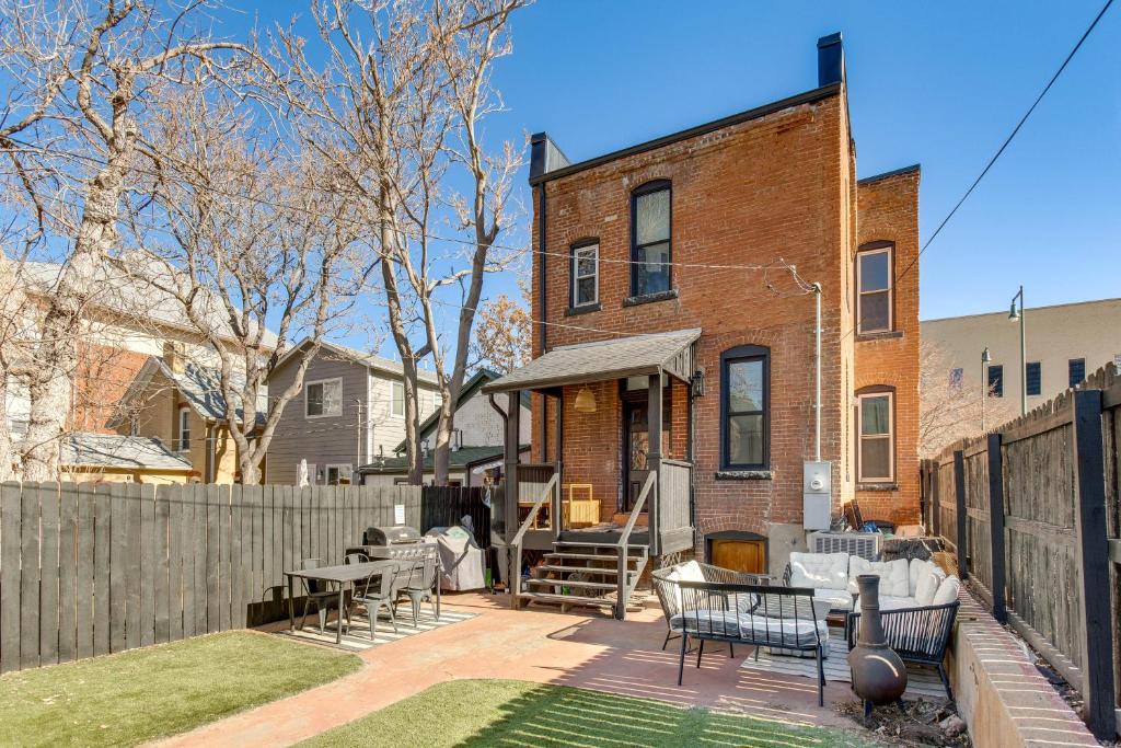 une arrière-cour avec une clôture et une maison en briques dans l'établissement Cozy Denver Studio with Patio - 1 Mi to Coors Field!, à Denver