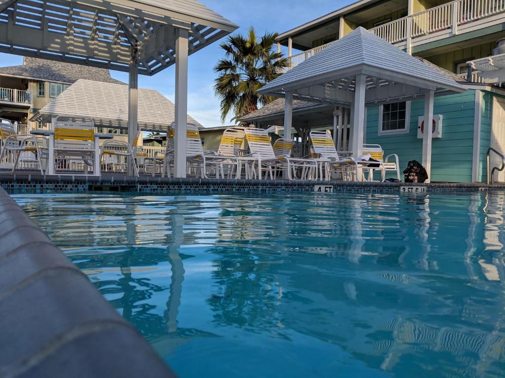 uma piscina num resort com cadeiras e condomínios em Seashell Village Resort near the beach with kitchens em Port Aransas