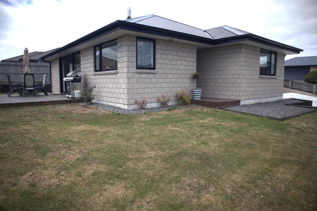 a small house with a lawn in front of it at Sunset Views in Kaikoura