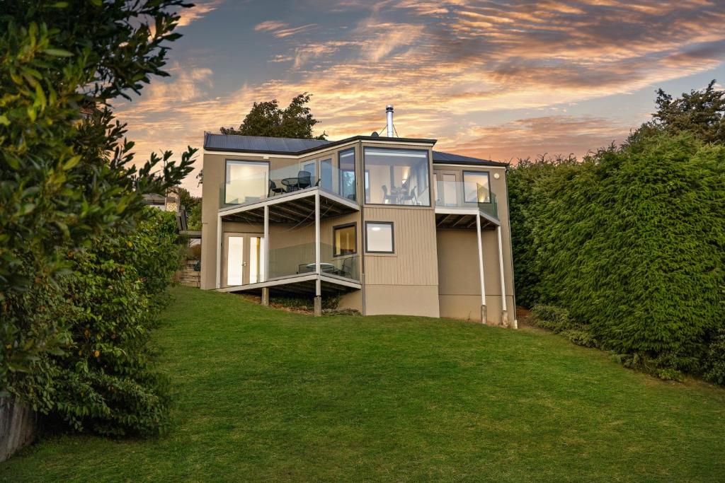 una gran casa en una colina con un patio en Sun-filled on Wakatipu - New Queenstown Listing, en Queenstown