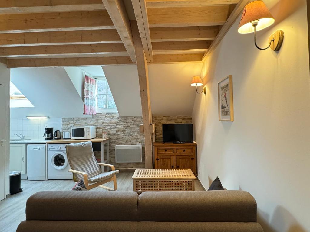 a living room with a couch and a kitchen at Charmant duplex pour 2/3 pers in Cauterets