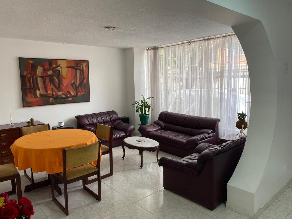 ein Wohnzimmer mit einem Sofa und einem Tisch in der Unterkunft El apartamento de Mario in Bogotá