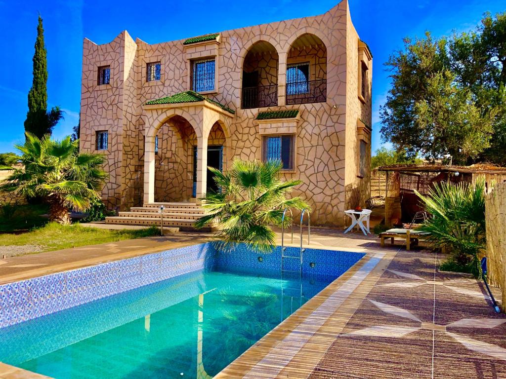 ein Haus mit einem Pool vor einem Gebäude in der Unterkunft Dar Zaouia , El Hanchane , Essaouira , Morocco 