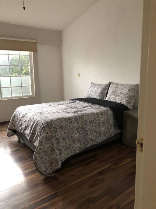 um quarto com uma cama e uma janela em Casa “Los Murales” em San José de Otates