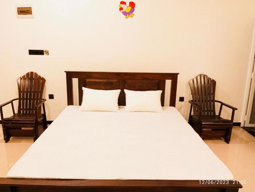 a bedroom with a bed and two chairs at The White House in Weligama