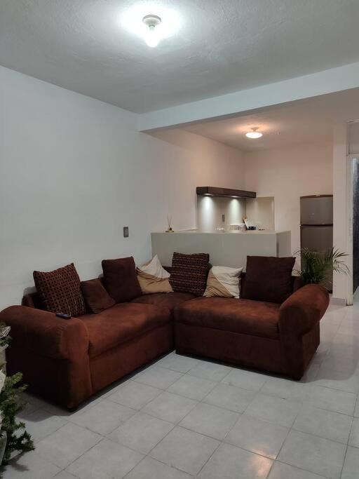 um sofá castanho sentado numa sala de estar em Departamento minimalista em Poza Rica de Hidalgo