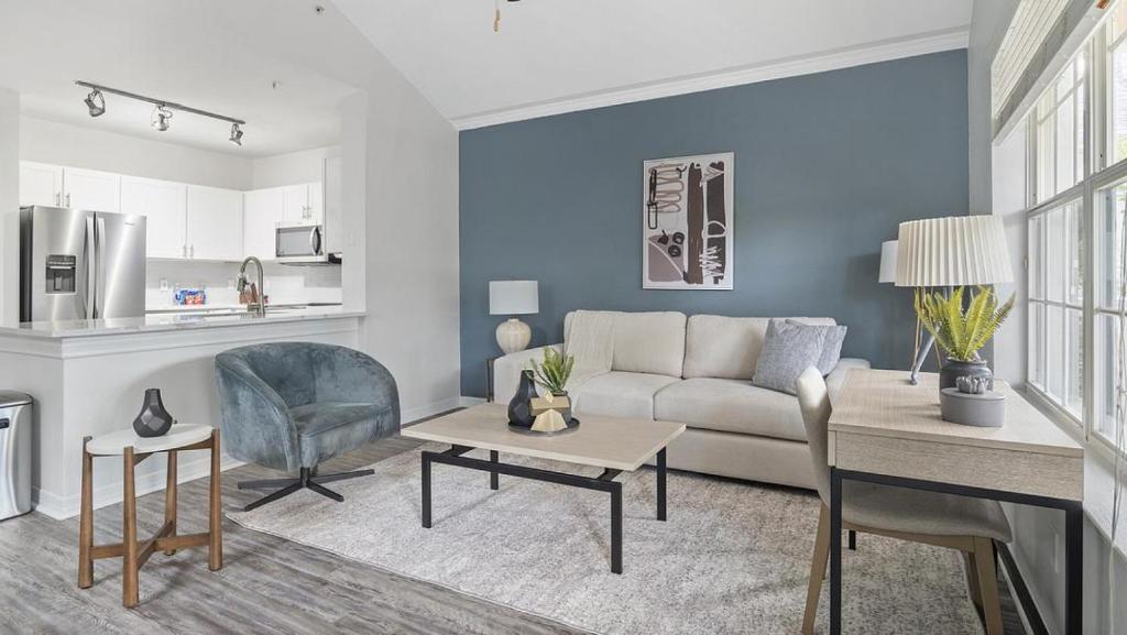 uma sala de estar com um sofá e uma mesa em Landing Modern Apartment with Amazing Amenities (ID3821X91) em Orlando