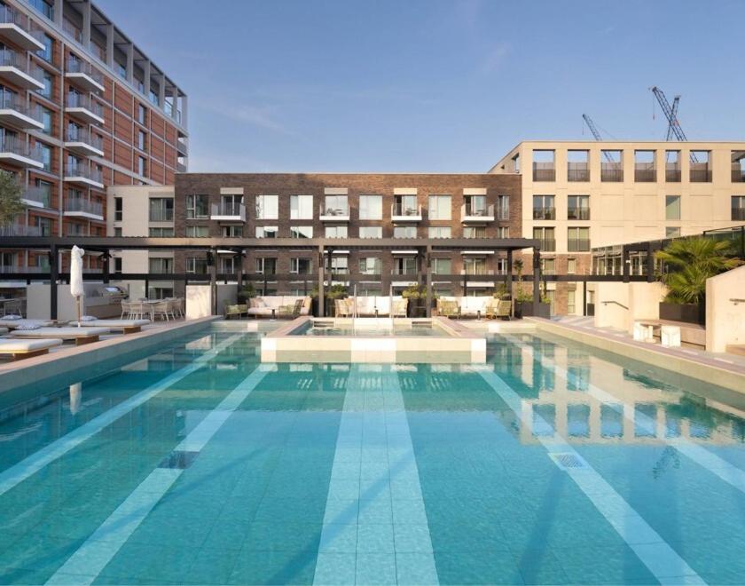 a large swimming pool in front of a building at Urban Rest Battersea Apartments in London