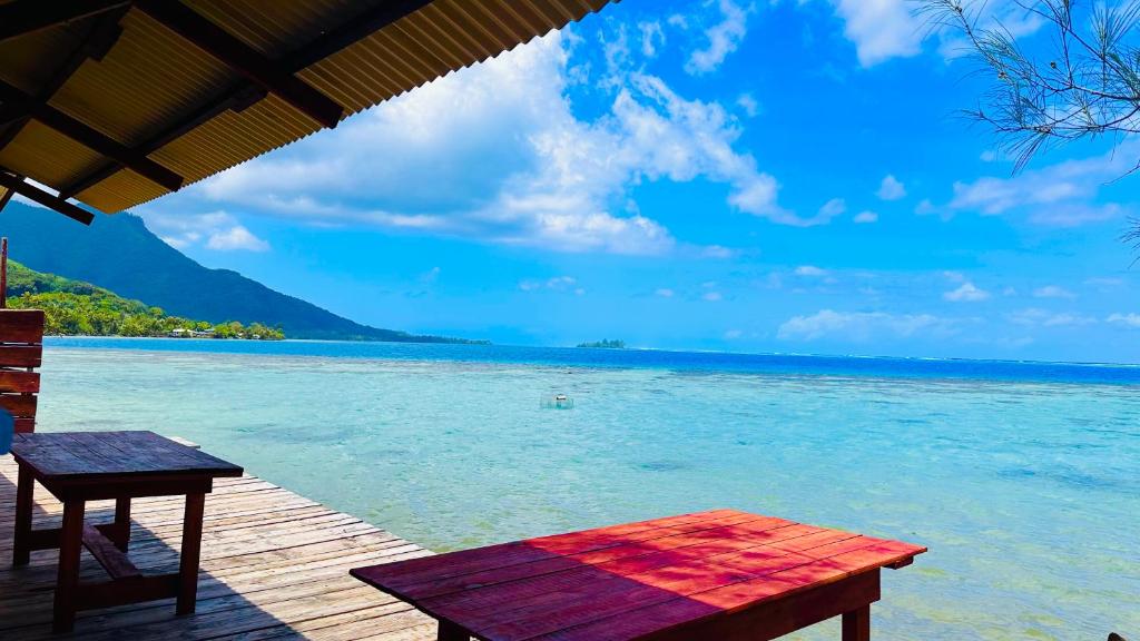 - une vue sur l'océan depuis un quai avec une table dans l'établissement Teraupoo Lodge Chalet, à Afareaitu