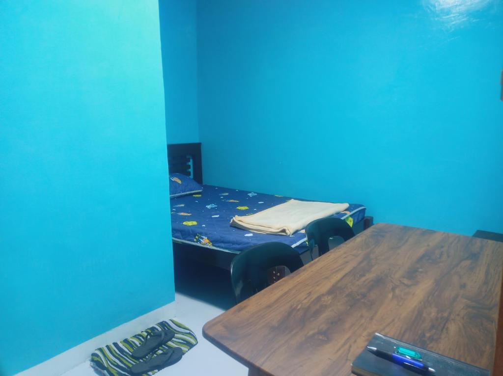 a room with a table and a bed with blue walls at Couple room blue RODEWAY HOUSE SPACE RENTAL in Pico