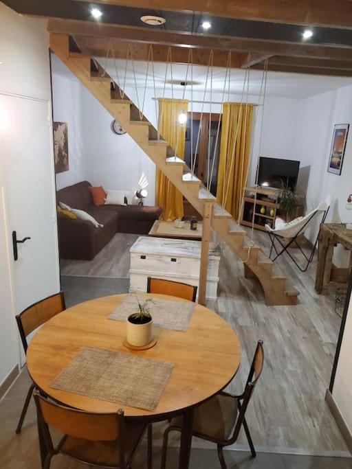 un salon avec une table et un escalier dans l'établissement Maison avec extérieur à 5 min du futuroscope, à Jaunay-Clan