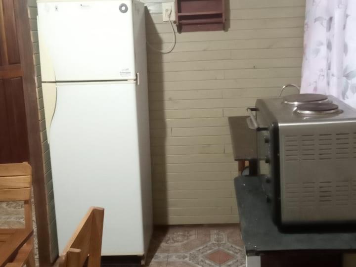uma cozinha com um frigorífico branco e um micro-ondas em Cabañas Guaimbe em Eldorado