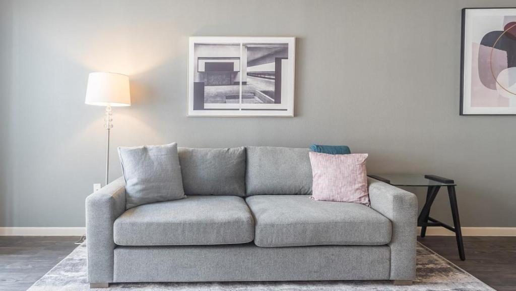 a gray couch in a living room with a lamp at Landing Modern Apartment with Amazing Amenities (ID5072X49) in Austin