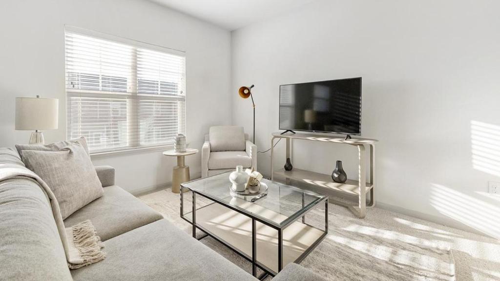 ein weißes Wohnzimmer mit einem Sofa und einem TV in der Unterkunft Landing Modern Apartment with Amazing Amenities (ID9550X82) in Forney