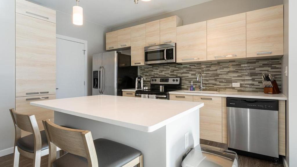 a kitchen with a white counter top and wooden cabinets at Landing Modern Apartment with Amazing Amenities (ID8359X76) in Newport