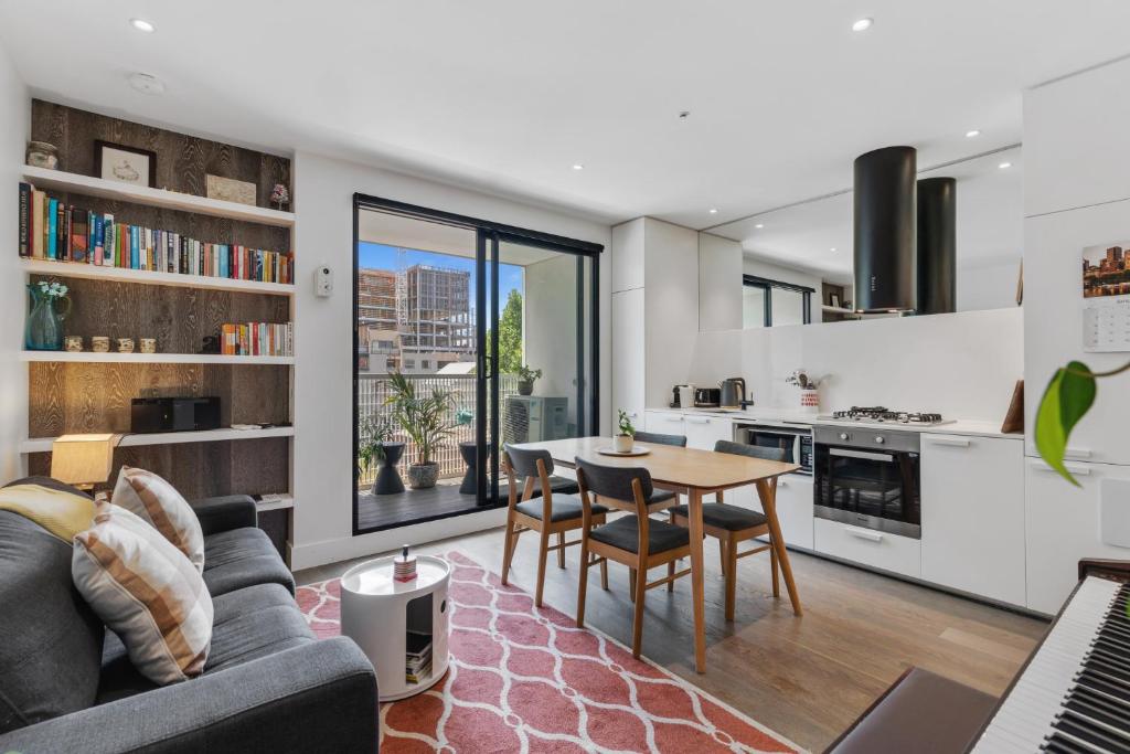een keuken en een woonkamer met een tafel en stoelen bij Lovely & Quiet 2-Bed in the Heart of Carlton in Melbourne