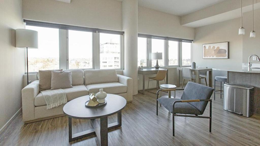 ein Wohnzimmer mit einem Sofa und einem Tisch in der Unterkunft Landing Modern Apartment with Amazing Amenities (ID1220X094) in Omaha
