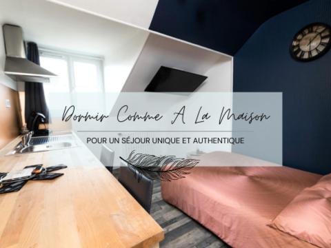 1 dormitorio con escritorio y reloj en la pared en NUIT BY LIGHT - Dormir Comme A La Maison en Châteaubriant