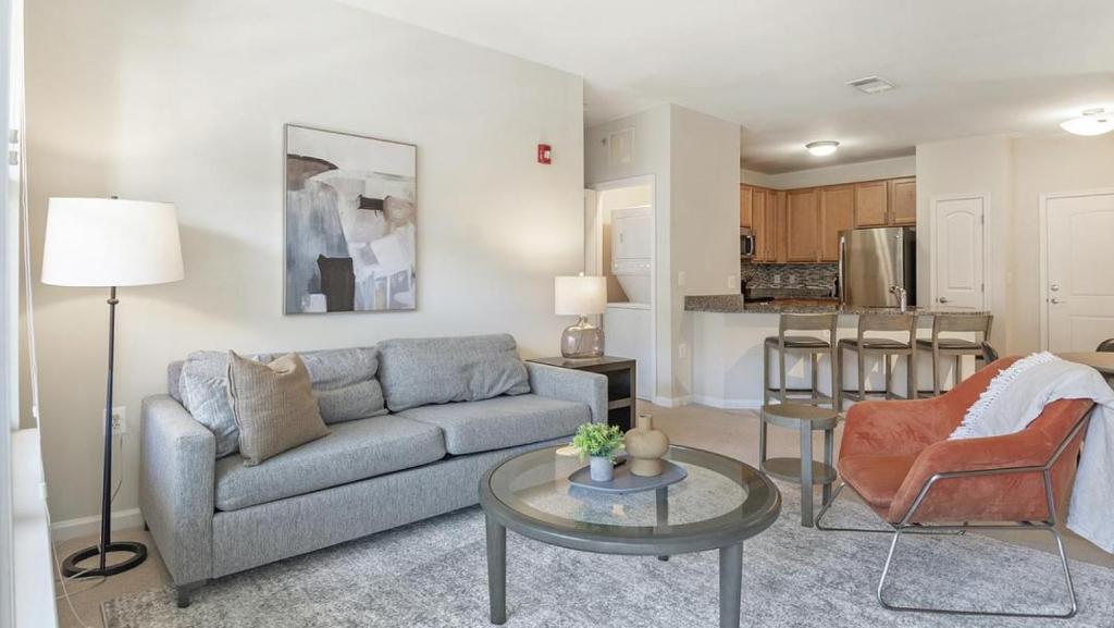 uma sala de estar com um sofá e uma mesa em Landing Modern Apartment with Amazing Amenities (ID7965X79) em Leesburg