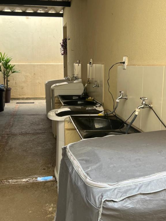 Habitación hospitalaria con cama y lavabo en Kit Net Vitoria 01, en Bauru