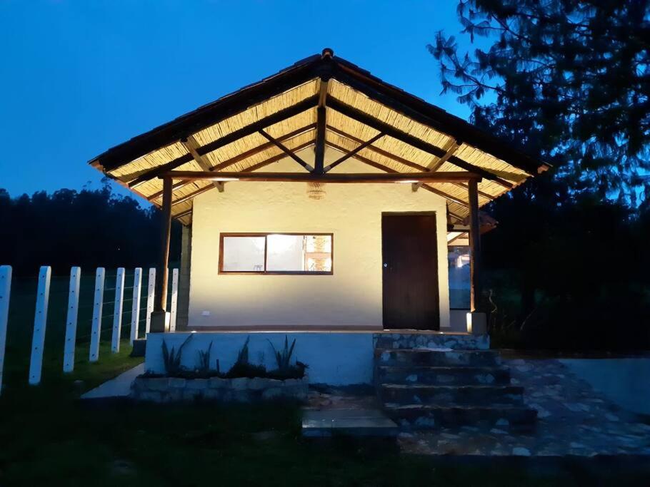 a small house with a pitched roof with a door at Linda mini casa campestre con Jacuzzi, chimenea... in Paipa
