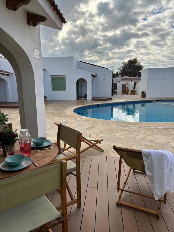 a patio with a table and chairs next to a pool at Apartamento nº 1 Cala Blanca in Cala Blanca